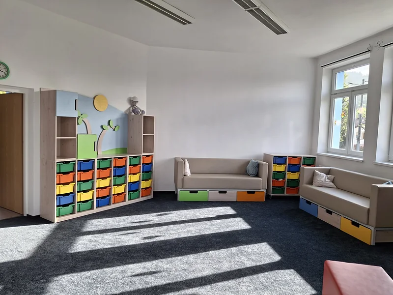 Koutek s pohovkami a úložnými boxy