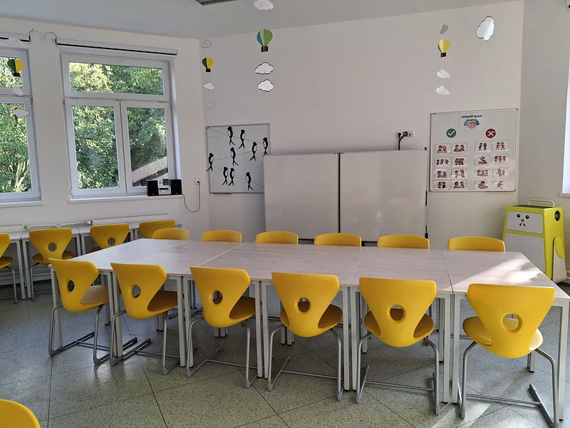 Místnost družiny se stoly a žlutými židlemi